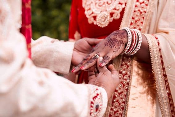 La main d'une mariée indienne recevant une bague.