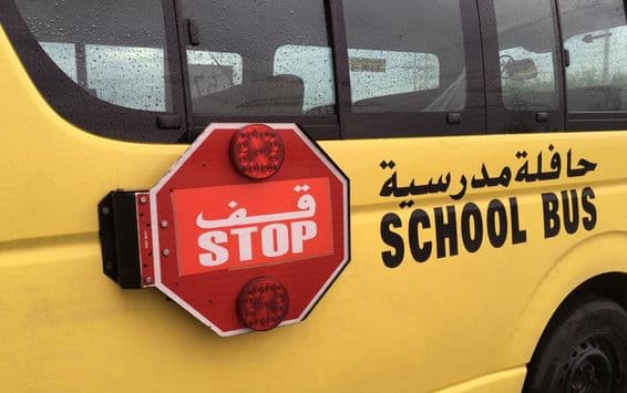 Un bus scolaire vide avec un panneau d'avertissement stop rouge.