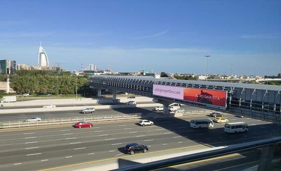 Route de Dubaï, grand panneau publicitaire en bord de route.