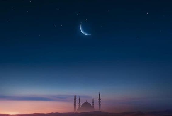 Mosquée au coucher du soleil avec la lune dans le ciel.