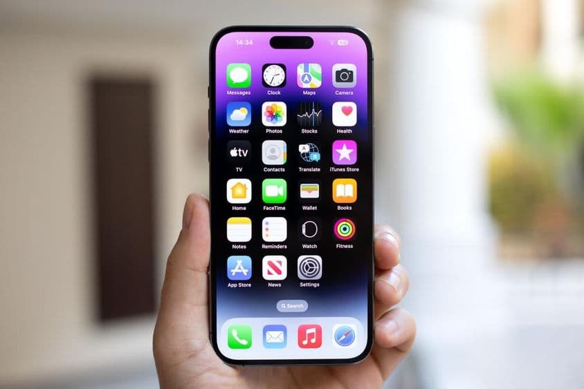 iPhone 15 Pro Max dans la main d'un homme.