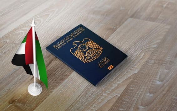 Passeport des Émirats Arabes Unis sur une surface en bois, avec un drapeau national.