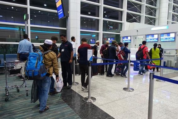 Des personnes font la queue pour l'embarquement à la porte de l'aéroport international de Dubaï.