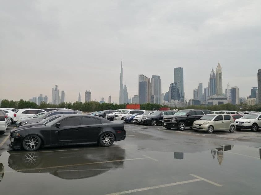 Après une forte pluie, l'eau de pluie stagne au sol dans le parking d'un pays désertique.
