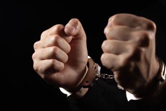 Hommes menottés arrêtés pour crimes.