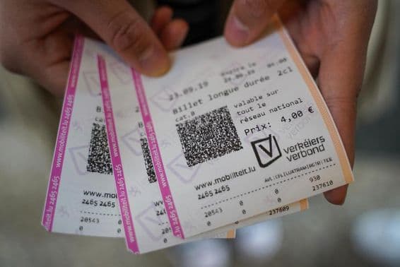 Un jeune homme tenant des billets à la main.