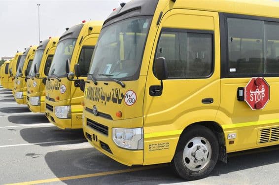 Plusieurs bus scolaires jaunes alignés dans un parking à Dubaï.