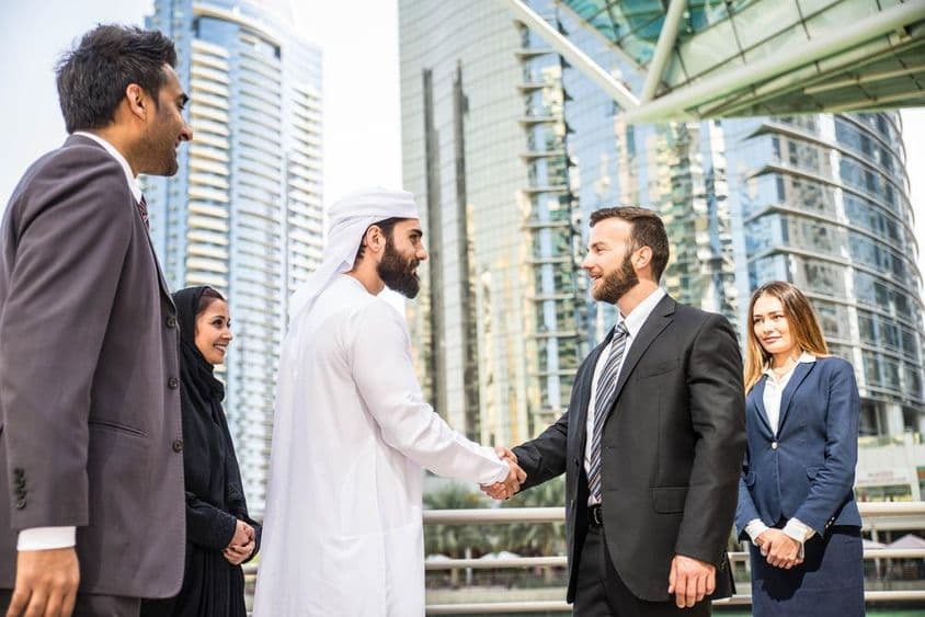 Groupe multinational de hommes d'affaires se rencontrant en plein air à Dubaï.