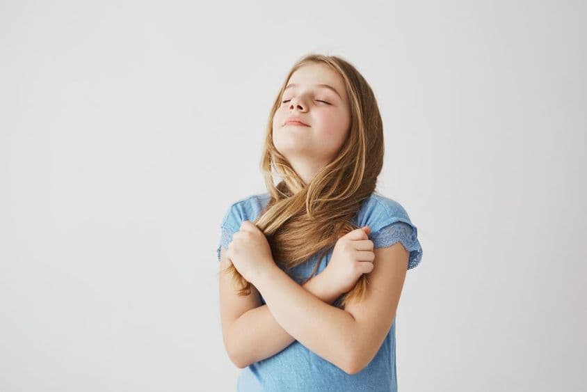 Jolie fillette blonde prend une grande respiration d'air frais.