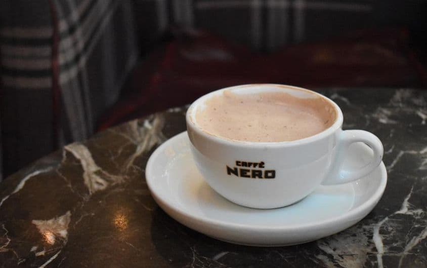 Une tasse de chocolat chaud sur une table en marbre chez Caffe Nero.