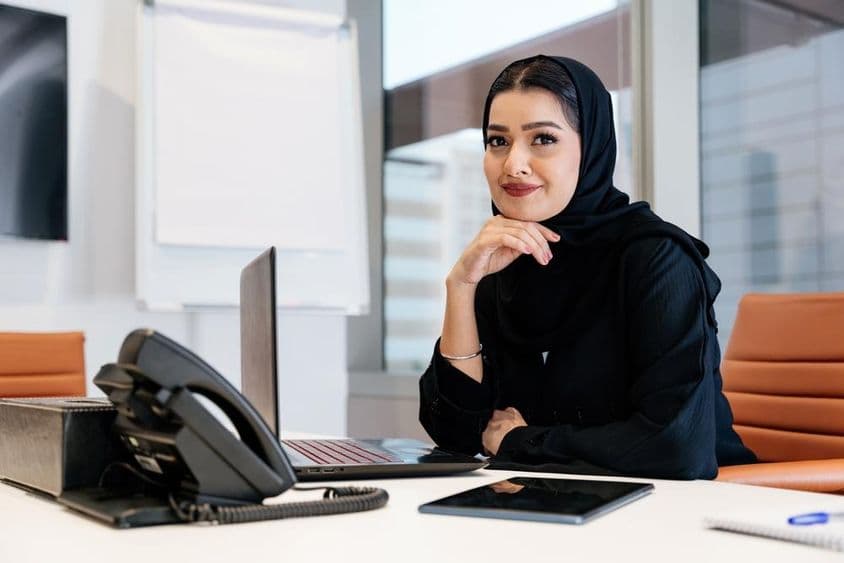 Femme d'affaires moyen-orientale portant une abaya arabe traditionnelle au bureau.