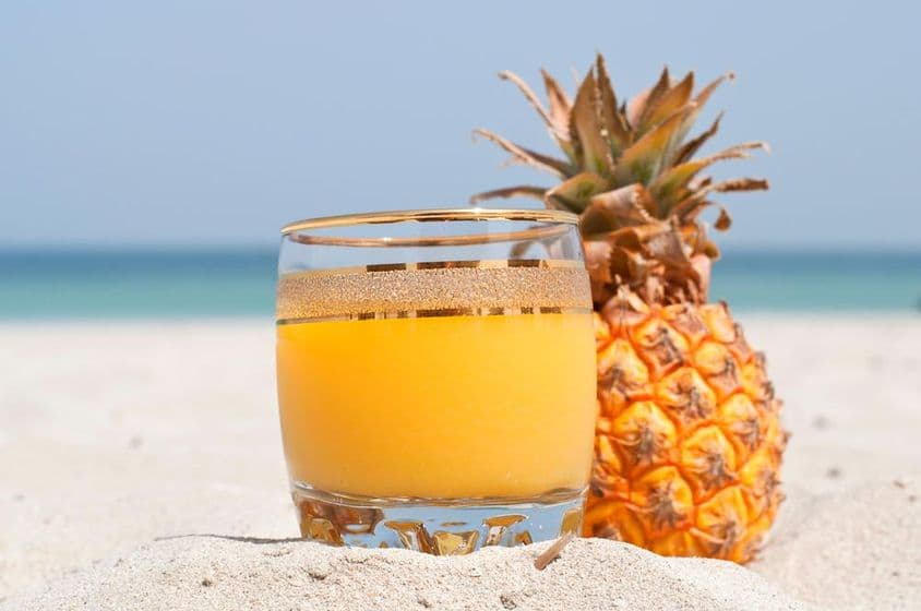 Un verre de jus d'ananas sur la plage.