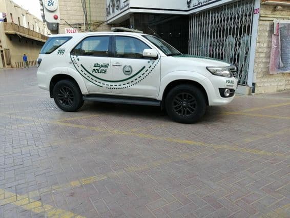 Une voiture de police de Dubaï vue de côté sur une rue.