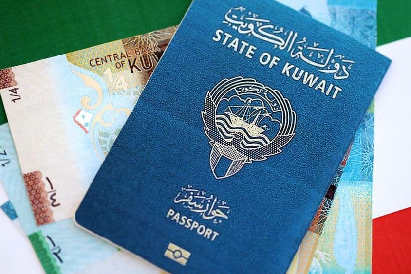Dinar koweïtien et passeport posés sur une table.