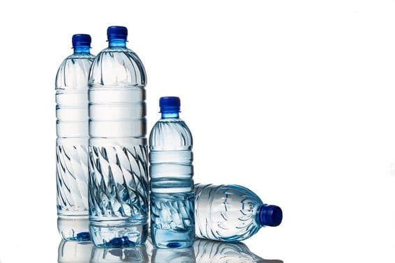 Quatre bouteilles en plastique d'eau minérale naturelle rafraîchissante.