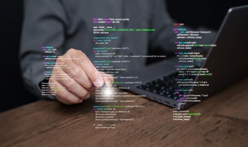 Les mains d'un programmeur sur un ordinateur portable avec un code.