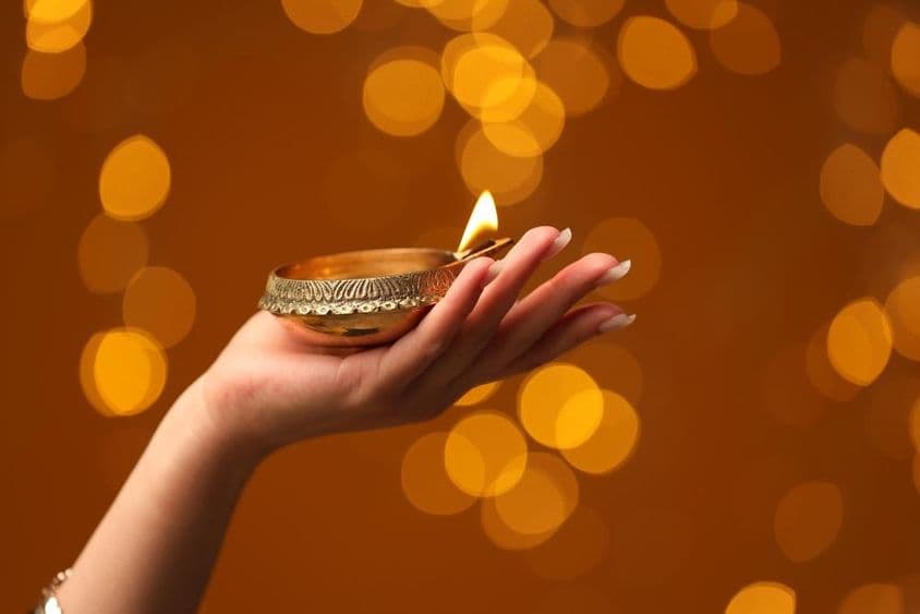 Femme tenant une lampe de Diwali allumée