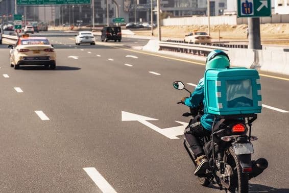 Dubaï, homme sur moto pour livraison de repas en ligne.