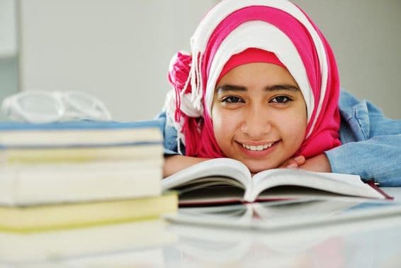 Belle jeune fille arabe musulmane lisant à l'université.