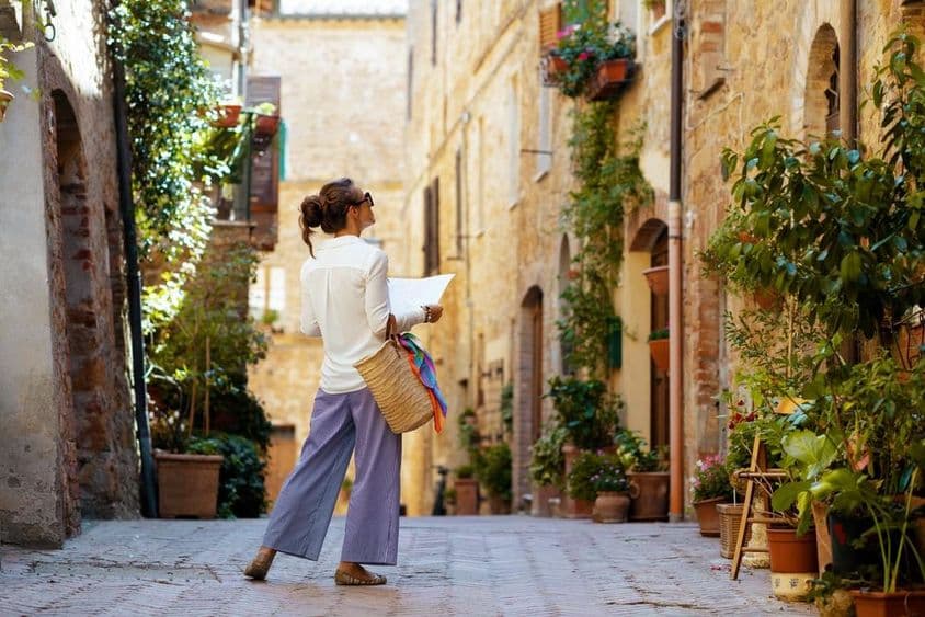 Une femme avec une carte et un chapeau de paille, profitant de la promenade en Toscane, Italie.