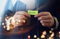 Un homme d'affaires montrant un document avec le mot 'don'.
