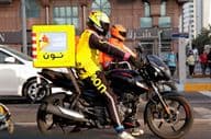 Coursier à moto livrant dans une rue de Dubaï.