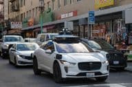 Robotaxi Waymo naviguant dans les rues étroites et animées de Chinatown à San Francisco.