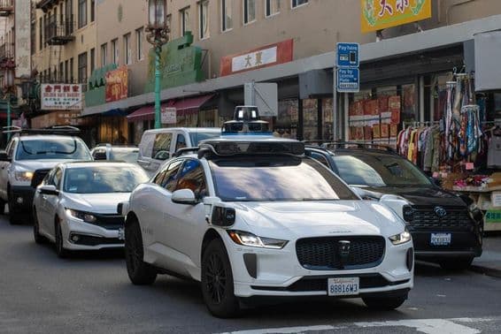 Robotaxi Waymo naviguant dans les rues étroites et animées de Chinatown à San Francisco.