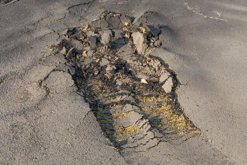 La surface d'asphalte de la rue a été retirée en raison d'une mauvaise exécution.