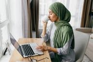 Femme d'affaires arabe vérifiant les notifications par email sur un ordinateur portable.