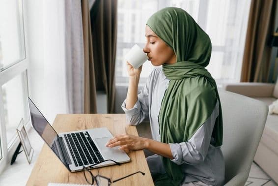 Femme d'affaires arabe vérifiant les notifications par email sur un ordinateur portable.