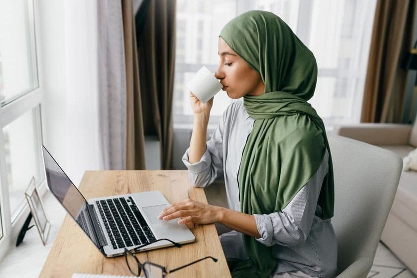 Femme d'affaires arabe vérifiant les notifications par email sur un ordinateur portable.