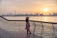 Jeune femme regardant le skyline de Dubaï au coucher du soleil.