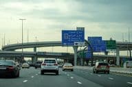 Route de Dubaï avec une voiture et une publicité sur un viaduc.