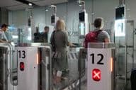 Passagers aériens traversant des points de contrôle automatisés pour passeports.