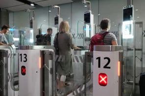 Passagers aériens traversant des points de contrôle automatisés pour passeports.