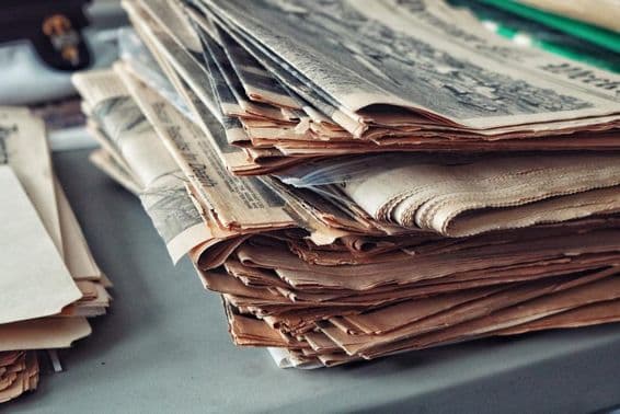 Anciens journaux empilés avec des toiles d'araignée.