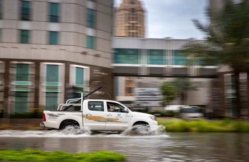 Voiture traversant une rue inondée à Dubaï.