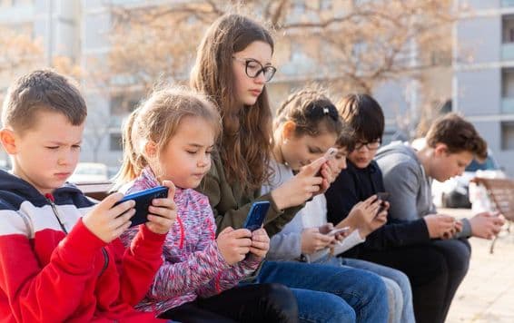 Des enfants communiquant via la messagerie sur un smartphone.