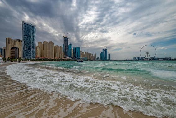 Mauvais temps à Dubaï avec pluie, vents forts, et vagues le long de la rive.