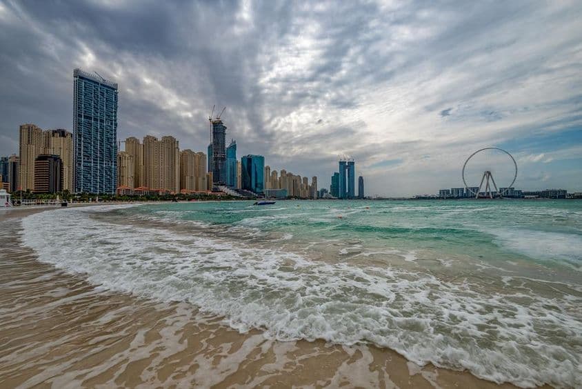 Mauvais temps à Dubaï avec pluie, vents forts, et vagues le long de la rive.