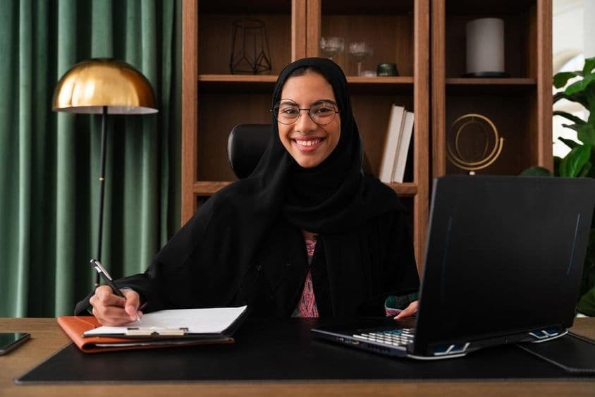Femme d'affaires à Dubaï portant une abaya dans un bureau.