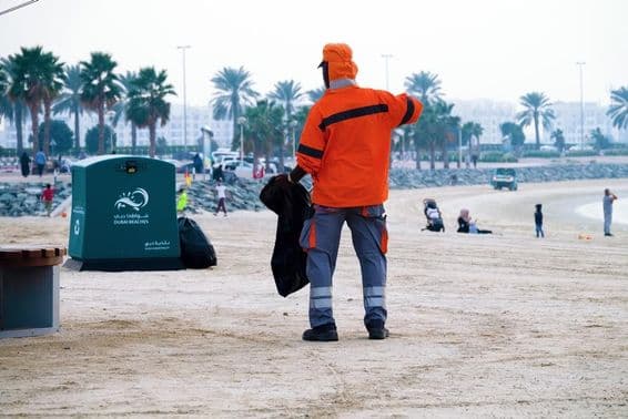 Dubaï, Émirats Arabes Unis, travailleur nettoyant la plage.