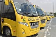 Plusieurs bus scolaires jaunes alignés dans un parking à Dubaï.