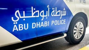 Voiture de police d'Abou Dhabi avec lettrage en anglais et en arabe.