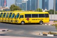 Alignement de bus scolaires jaunes de Dubaï garés à l'extérieur.