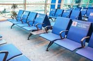 Rangées de sièges dans une zone d'attente d'aéroport.