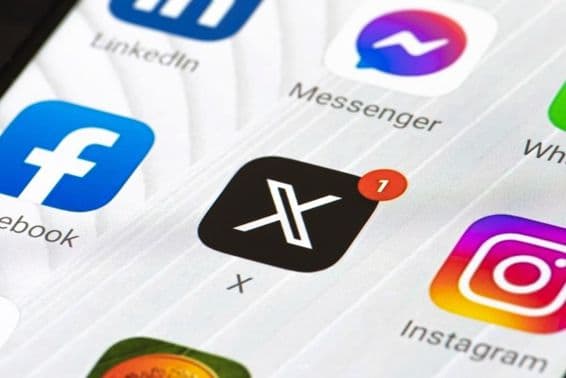 Logo Twitter ou X avec lettre initiale et application sur smartphone.