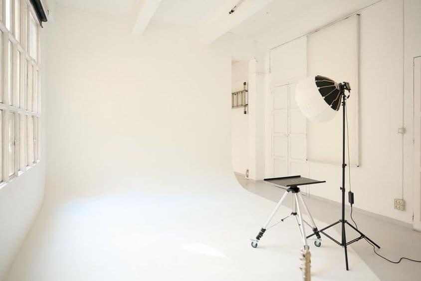 Studio photo vide équipé de luminaires, prêt pour une séance.