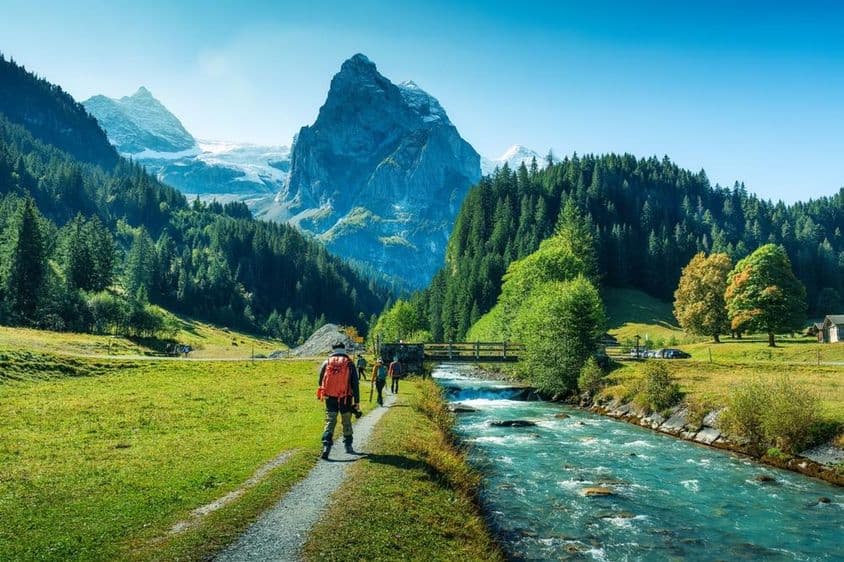 Groupe de touristes marchant le long d'une rivière dans une forêt dans le canton de Berne, Suisse.